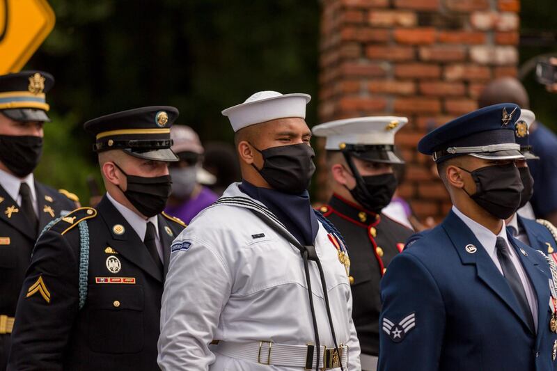 Military pallbearers wear face masks as part of the coronavirus-enhanced measures for Lewis's memorial. AFP