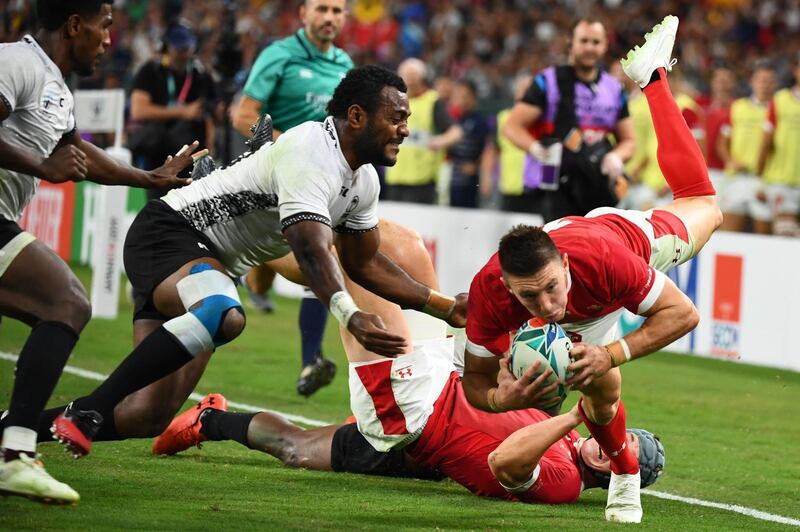 Wales' wing Joshua Adams (R) scores a try past Fiji's scrum-half Frank Lomani (L) and Fiji's full back Kini Murimurivalu during the Japan 2019 Rugby World Cup Pool D match between Wales and Fiji at the Oita Stadium in Oita. AFP