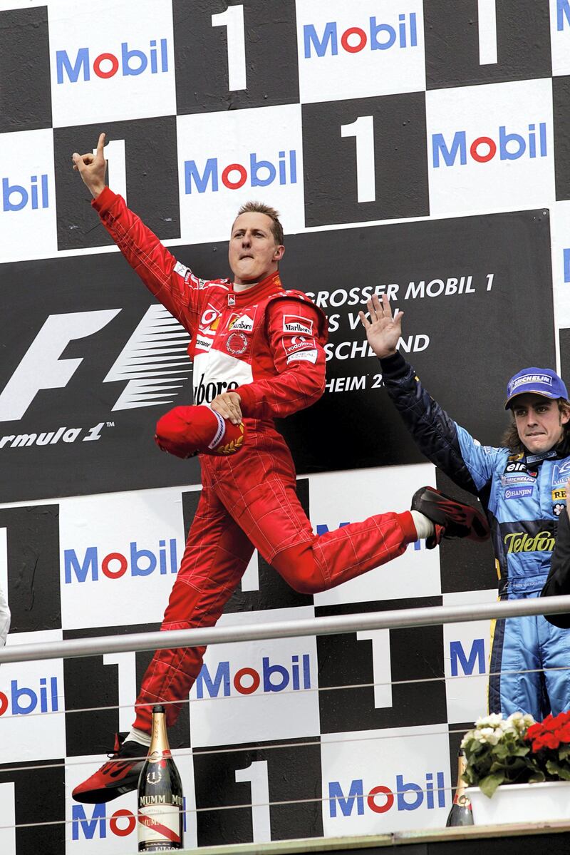 Michael Schumacher, Fernando Alonso, Grand Prix of Germany, Hockenheimring, 25 July 2004. Michael Schumacher performing one of his famous victory jumps on the podim of the 2004 Grand Prix of Germany. (Photo by Paul-Henri Cahier/Getty Images)