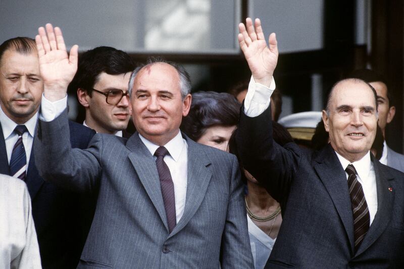 Gorbachev and Francois Mitterrand wave during an official trip by the French president to the USSR, in July 1986. AFP