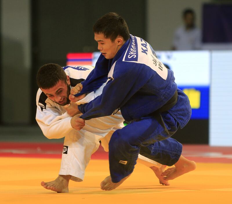 Magzhan Shamshadin, in blue from Kazakhstan, fights with Vahagn Hovsepyan from Armenia on the opening day of the International Judo Federation (IJF) Junior World Championships, which started at the Ipic Arena at the Zayed Sports City in Abu Dhabi on Friday. Ravindranath K / The National