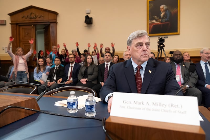 Demonstrators from Code Pink raise red-coloured hands as retired Gen Mark Milley, the former chairman of the Joint Chiefs of Staff, waits to appear before the House Foreign Affairs Committee to give evidence about the US withdrawal from Afghanistan, in Washington. AP