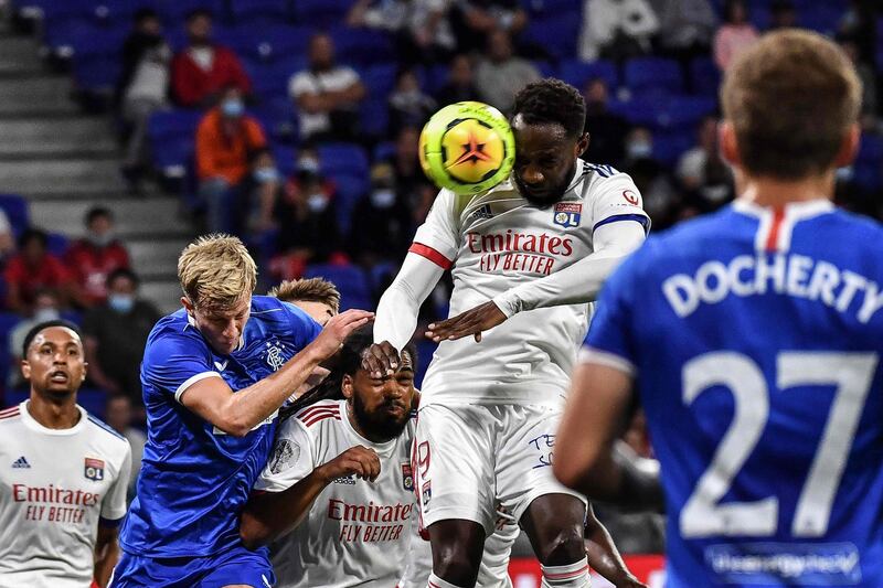 Lyon's Moussa Dembele, right, heads the ball in front of Rangers' midfielder Scott Arfield. AFP