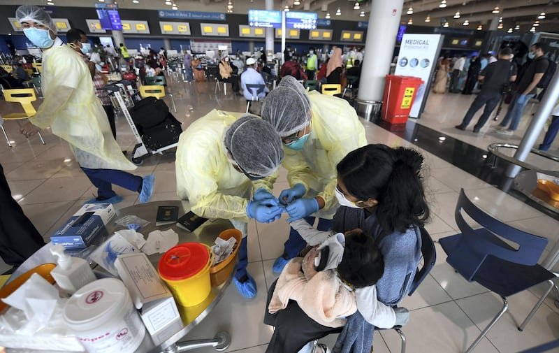 Health workers test a an Indian child held by a woman at the Dubai International Airport before leaving with other Indian nationals the Gulf Emirate on a flight back to their country, on May 7, 2020, amid the novel coronavirus pandemic crisis.  The first wave of a massive exercise to bring home hundreds of thousands of Indians stuck abroad was under way today, with two flights preparing to leave from the United Arab Emirates.
India banned all incoming international flights in late March as it imposed one of the world's strictest virus lockdowns, leaving vast numbers of workers and students stranded.

  


  
 / AFP / Karim SAHIB
