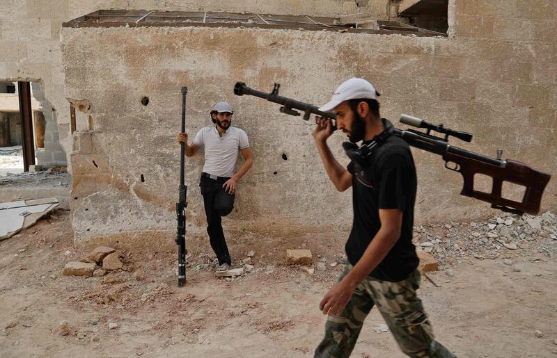 TOPSHOT - Syrian rebel fighters from the Faylaq al-Rahman brigade carry their homemade 12.7mm sniper rifle in Ain Tarma, in the eastern Ghouta area, a rebel stronghold east of the capital Damascus, on July 20, 2017.  / AFP PHOTO / ABDULMONAM EASSA