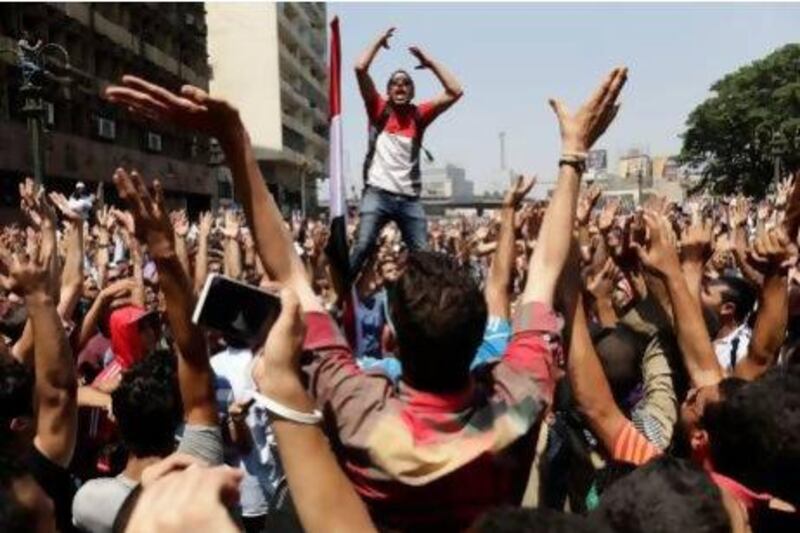 Supporters of Mohammed Morsi chant slogans against Egypt's military before clashes broke out in Cairo on Friday. Hassan Ammar / AP Photo