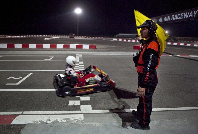 A race marshal waves off go kart drivers as they take off for the practice round while competing in the Ramadan Super Prix Challenge at the Al Ain Raceway Track in Al Ain. Abdullah Suleiman Al Rawahi (11) won the tournament, followed by his brother Sanad Suleiman al Rawahi. Silvia Razgova / The National




