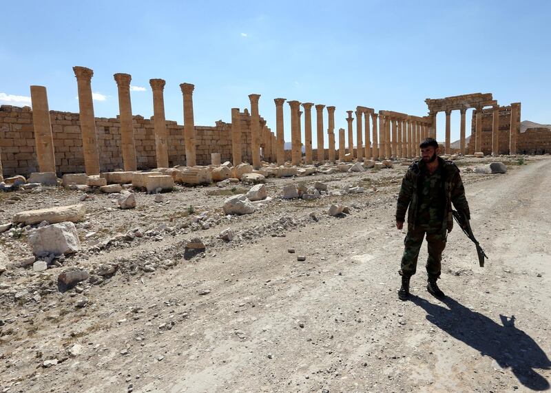 A Syrian soldier walks inside the compound of Palmyra's Temple of Bel in the ancient Syrian city on March 31, 2016. - The main building of the ancient temple was destroyed by jihadists of the Islamic State group as well as a row of columns in its immediate vicinity. Syrian troops backed by Russian forces recaptured Palmyra on March 27, 2016, after a fierce offensive to rescue the city from jihadists who view the UNESCO-listed site's magnificent ruins as idolatrous. (Photo by JOSEPH EID / AFP)