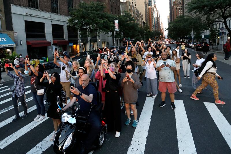 People gather along West 57th Street to take photos of Manhattanhenge. EPA