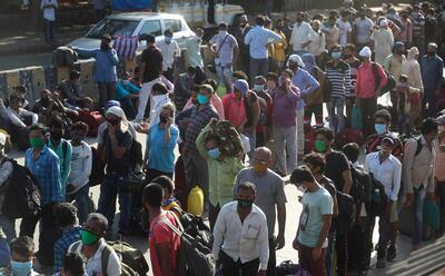 Migrant workers line up to board buses for their onward journey by train to their home states, at Dharavi, one of Asia's largest slums, in Mumbai, India, Friday, May 22, 2020. India's lockdown was imposed on March 25 and has been extended several times. On May 4, India eased lockdown rules and allowed migrant workers to travel back to their homes, a decision that has resulted in millions of people being on the move for the last two weeks. (AP Photo/Rafiq Maqbool)