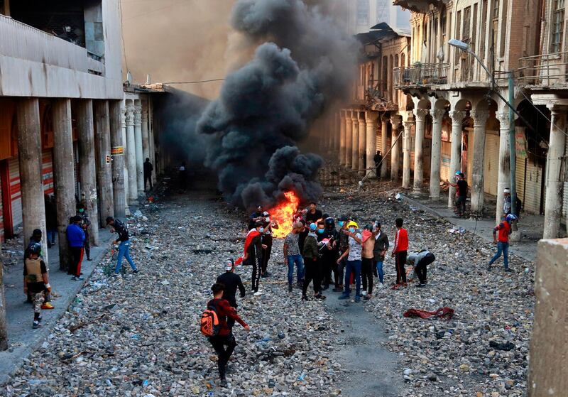 Anti-government protesters set fire while security forces close Rasheed Street during clashes in Baghdad, Iraq. AP