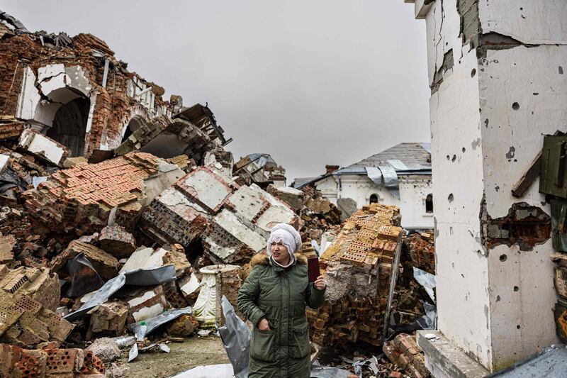 A local resident takes pictures of a destroyed monastery in Dolyna, eastern Ukraine. AFP