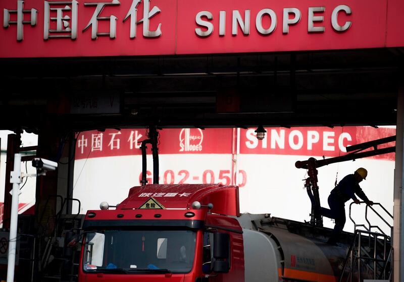 This picture taken on March 22, 2018 shows a man working in a filling station of Sinopec, China Petroleum and Chemical Corporation, in Shanghai. 
China launched yuan-denominated oil futures contracts on March 26, marking the first time foreign investors will have access to Chinese commodity futures as the world's top crude importer seeks greater influence over global prices. / AFP PHOTO / Johannes EISELE