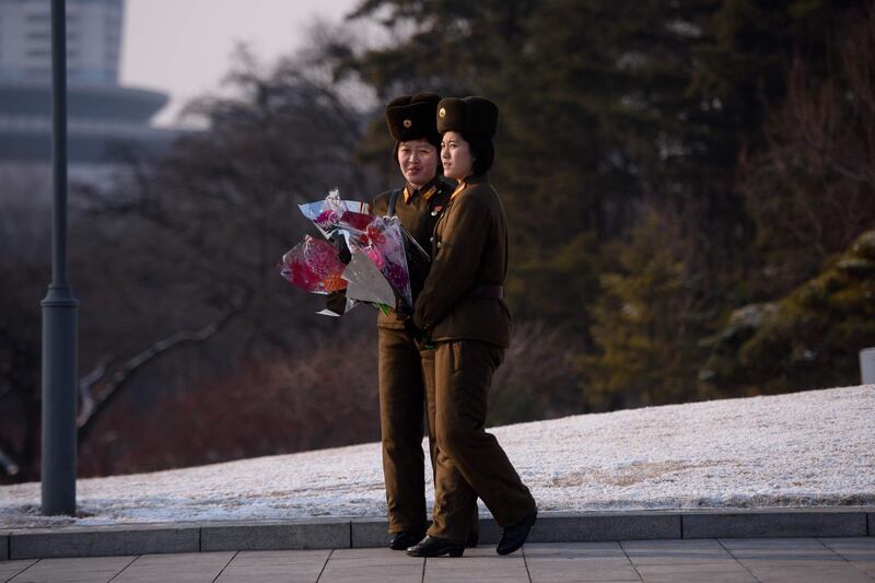 Korean People's Army soldiers carry flowers for Kim Jong Il. AFP