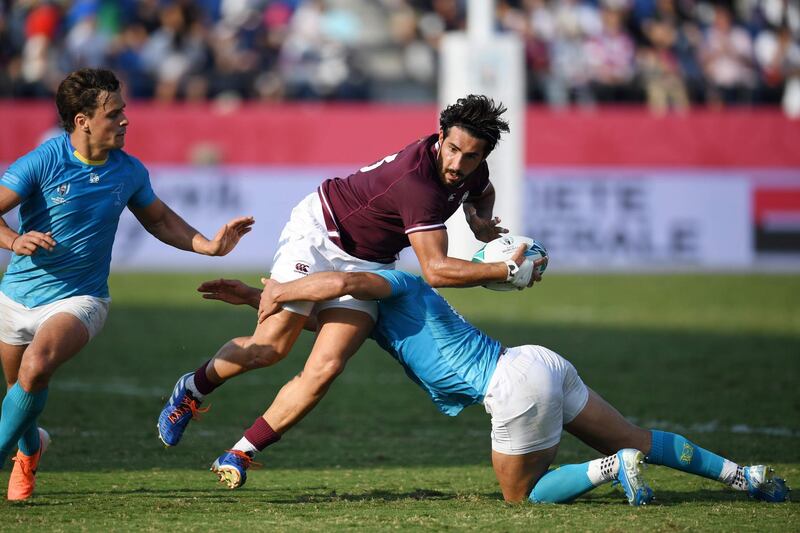 Georgia's Giorgi Kveseladze is tackled by Uruguay wing Nicolas Freitas at the Kumagaya Rugby Stadium on Sunday. AFP