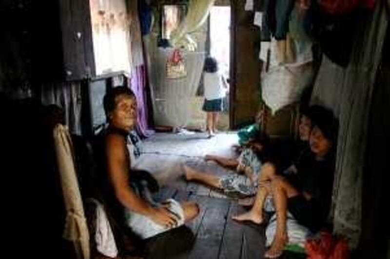 Robert, left, sits in his family's small shack in a Manila slum with some of their 10 children.

Credit: Jared Ferrie/The National *** Local Caption ***  Ferrie-Population1.JPG