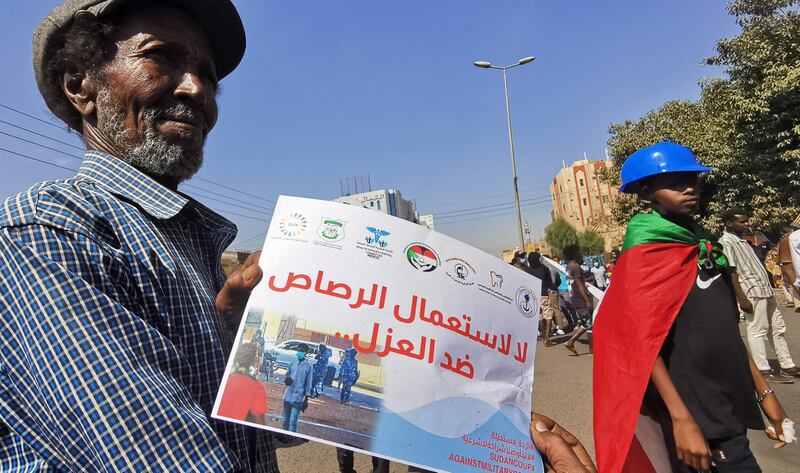 A Sudanese man , in the capital Khartoum holds a poster that reads in Arabic: ‘No to the use of live bullets against the unarmed’ during a protest against the October 2021 military coup. AFP