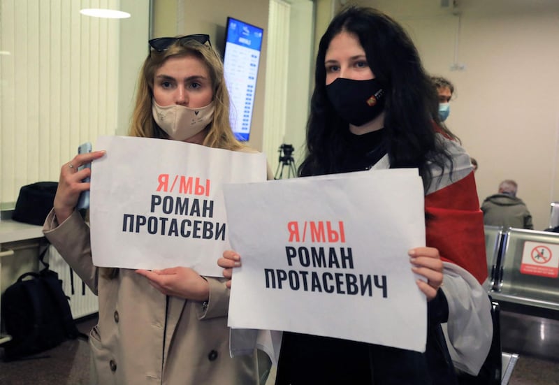 Women stand with posters reading 'I am, we are Roman Protasevich' in the arrival area as passengers disembark at the airport in Vilnius, its initial destination. AFP