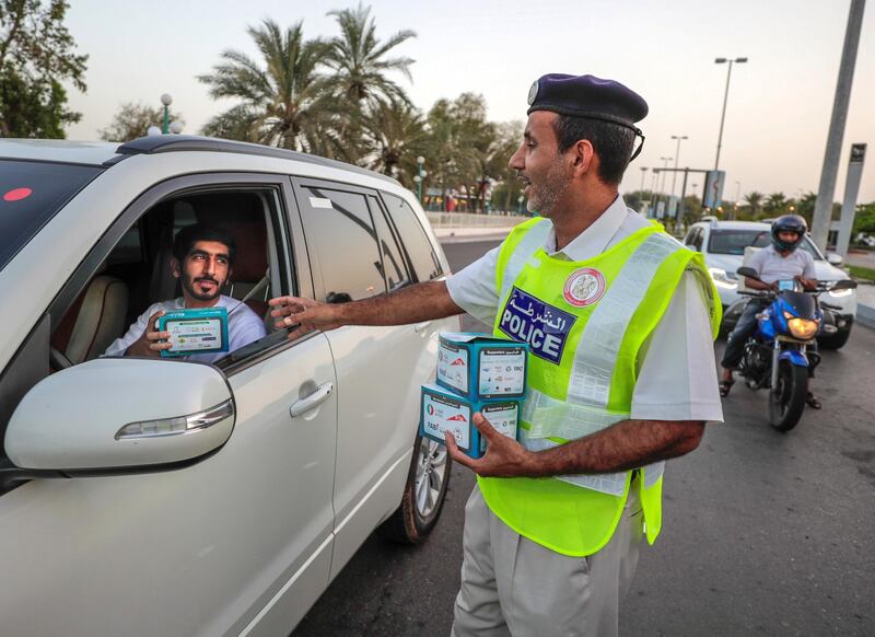 Abu Dhabi, United Arab Emirates, May 7, 2019.    Red Crescent volunteers and Abu Dhabi Police distribute food to motorists during iftar at the corner of 11th St. and 18th Sports City area.
Victor Besa/The National
Section:  NA
Reporter:  Haneen Dajani