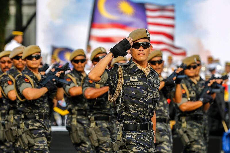 Armed forces personnel salute in a march past. EPA