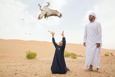 AL AIN, UNITED ARAB EMIRATES - Ali Al Shamsi from IFHC with his son Salem at the release of 50 Houbara birds into their Habitat of the UAE desert by The International Fund for Houbara Conservation (IFHC). Leslie Pableo for The National