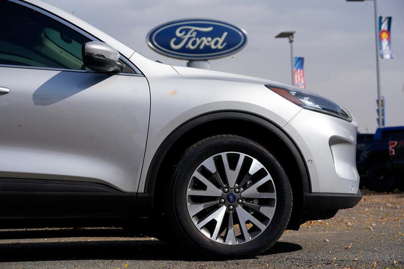 FILE - In this Sunday, Oct. 11, 2020 file photo, A row of 2020 Ford Escape sports-utility vehicles sits at a Ford dealership in Denver. A widening global shortage of semiconductors for auto parts is forcing major auto companies to halt or slow vehicle production just as they were recovering from pandemic-related factory shutdowns. Ford had scheduled down time next week at its Louisville, Kentucky, assembly plant, but moved it ahead to this week. The plant makes the Ford Escape and Lincoln Corsair small SUVs.  (AP Photo/David Zalubowski, File)