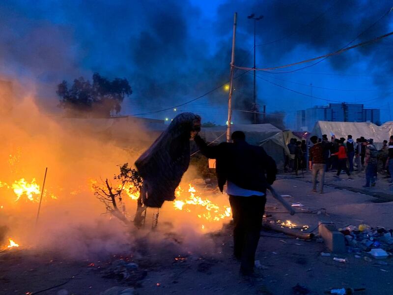 Anti-government protesters try to extinguish their burning tents in Najaf, Iraq, Wednesday, February 5, 2020. IAP Photo