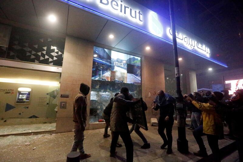 Protesters smash the window of a bank as demonstrations against the economic crisis continue in Beirut, Lebanon.  Reuters