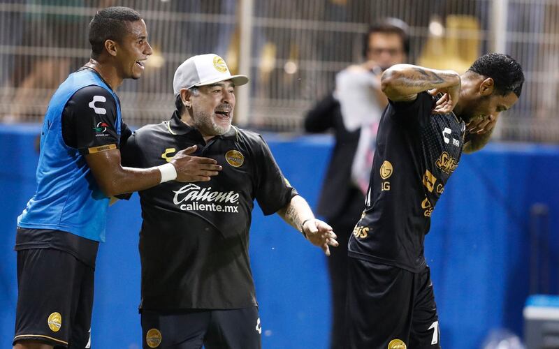 Maradona celebrates a goal by Vinicio Angulo, far right. AP Photo