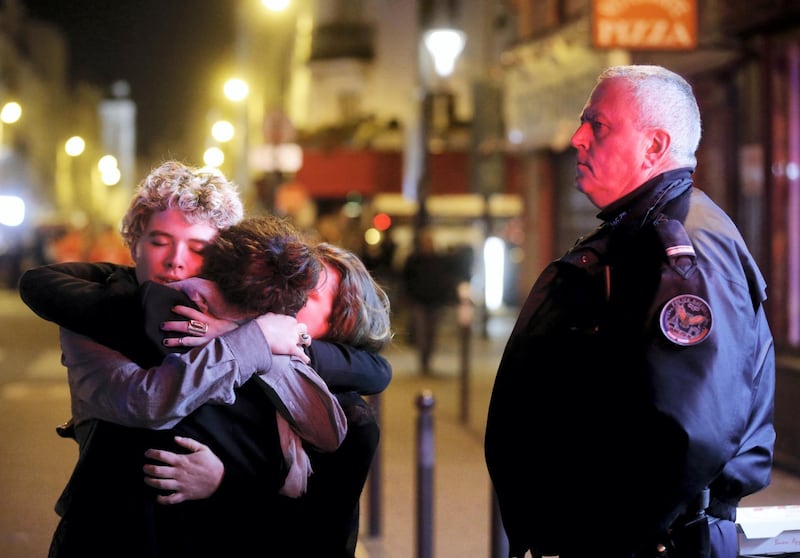 People hug on the street near the Bataclan concert hall following fatal attacks in Paris, France, November 14, 2015. Gunmen and bombers attacked busy restaurants, bars and a concert hall at locations around Paris on Friday evening, killing dozens of people in what a shaken French President described as an unprecedented terrorist attack.    REUTERS/Christian Hartmann   - GF20000058600