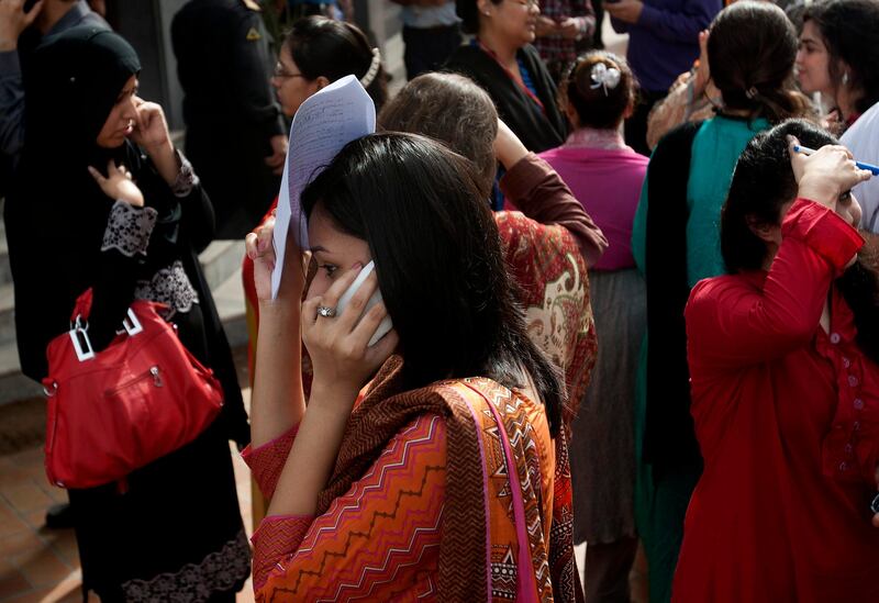 People evacuate buildings and call their relatives after a tremor of an earthquake was felt in Karachi, Pakistan, Tuesday, April 16, 2013. A major earthquake described as the strongest to hit Iran in more than half a century flatted homes and offices Tuesday near Iran's border with Pakistan, killing at least tens of people in the sparsely populated region and swaying buildings as far away as New Delhi and the skyscrapers in Dubai and Bahrain. (AP Photo/Shakil Adil) *** Local Caption ***  Pakistan Quake.JPEG-04558.jpg