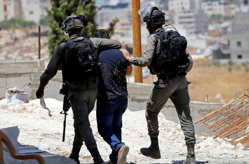 An Israeli border policeman grabs a Palestinian demonstrator during a protest against the Israeli demolitions of Palestinian homes in the village of Sur Baher which sits on either side of the Israeli barrier in East Jerusalem and the Israeli-occupied West Bank August 2, 2019. REUTERS/Mussa Qawasma