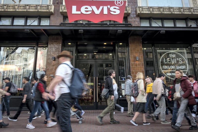 Pedestrians walk in front of the Levi Strauss & Co. flagship store in San Francisco, California, U.S., on Monday, March 18, 2019. Levi Strauss & Co.'s initial public offering, currently set at 36.7 million shares seen pricing at $14 to $16 each, is expected to price on March 20 according to the NYSE website. Photographer: David Paul Morris/Bloomberg