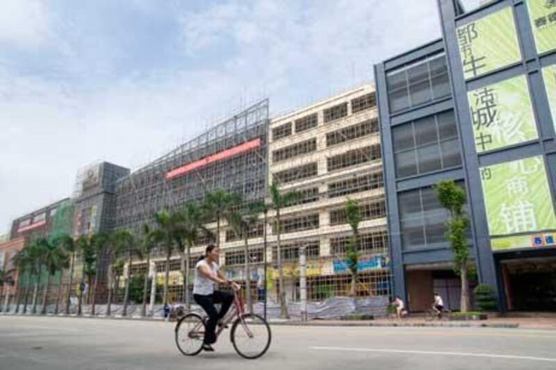 A cyclist passes the long bamboo-scaffolded eastern facade of the South China Mall. Philip Gostelow for The National