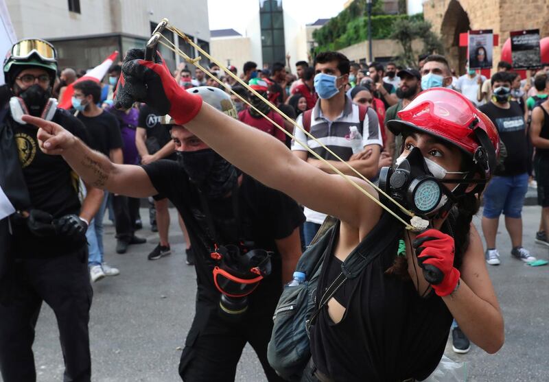 An anti-government protester uses a slingshot to launch a stone towards Lebanese riot police. AP