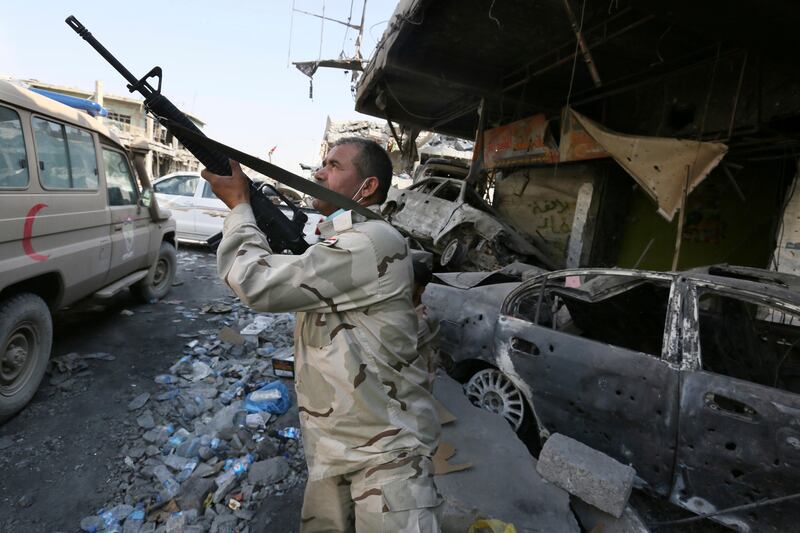 An Iraqi soldier looks out at old town of Mosul after the recapture of the city was announced on July 10, 2017. However, fighting continued in the city and ISIL still has thousands of fighters in Iraq, officials say. The Yomiuri Shimbun via AP Images