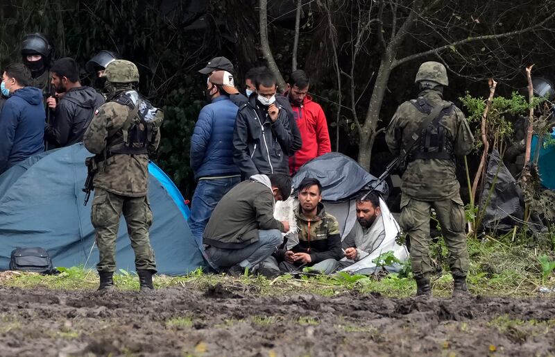 Polish security forces surround a group of migrants who are stuck at the border with Belarus. AP