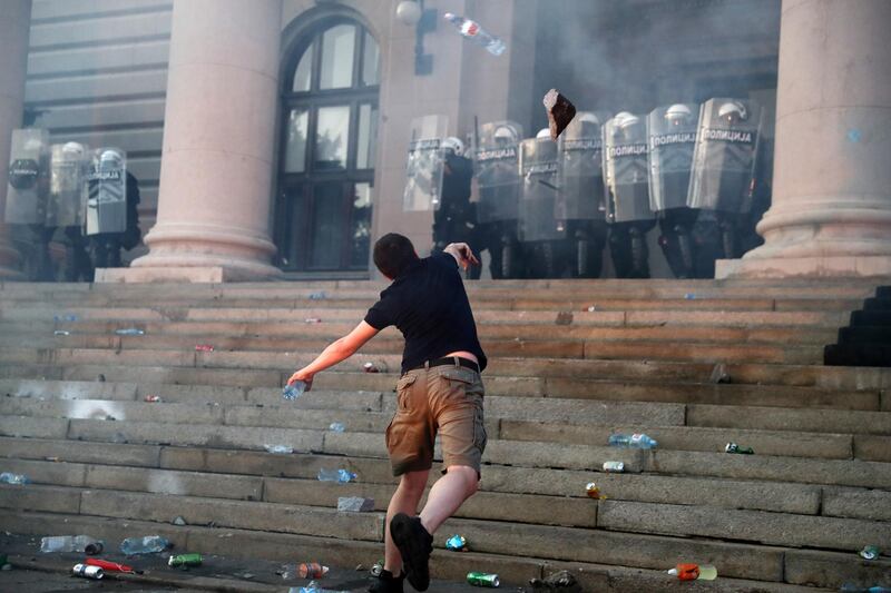 A protestor throws a rock as demonstrators clash with police during an anti-government rally in front of the parliament building in Belgrade, Serbia. Reuters