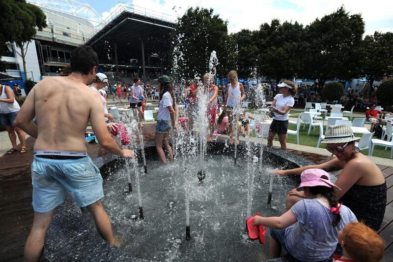 Fans cool off from the intense Australian heat at a fountain in Melbourne Park on Wednesday.