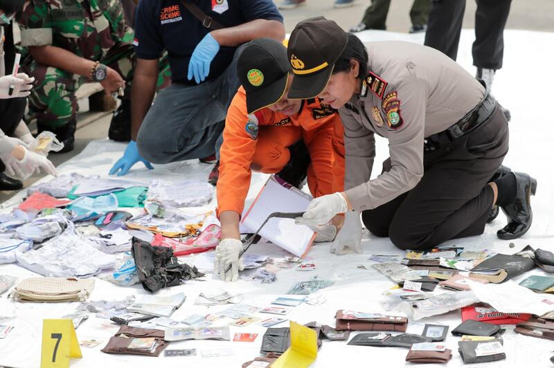 Indonesian rescuers collect and classify wreckage pieces and passenger belongings from the crash. EPA