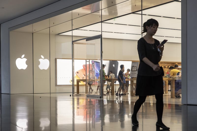 A woman walks past an Apple Inc. store in Xiamen, China, on Monday, Aug. 26 2019. U.S. companies are concerned about President Donald Trump’s threats to ban them from doing business in China, and they’re poised to halt new investments if the trade war escalates, the leader of group of top chief executive officers said. Photographer: Qilai Shen/Bloomberg