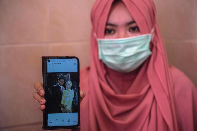 Berda Asmara shows a wedding photo with her sailor husband Mes Guntur Ari Prasetyo at their home in Surabaya. AFP