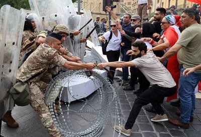 Activists confront soldiers guarding the entrance of the Lebanese parliament building during a demonstration in Beirut on August 4, 2022, on the day that crisis-hit Lebanon marks two years since a giant explosion ripped through the capital. AFP