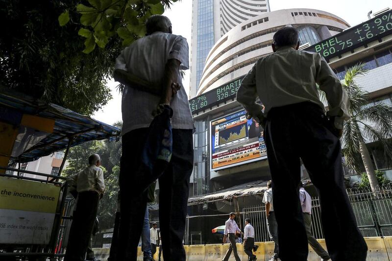 Men look up at an electronic ticker board at the Bombay Stock Exchange (BSE) in Mumbai. Dhiraj Singh / Bloomberg