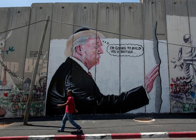 A mural resembling the work of elusive artist Banksy depicting President Donald Trump wearing a Jewish skullcap, is seen on Israel's West Bank separation barrier in the West Bank city of Bethlehem, Friday, Aug. 4, 2017. (AP Photo/Nasser Nasser)