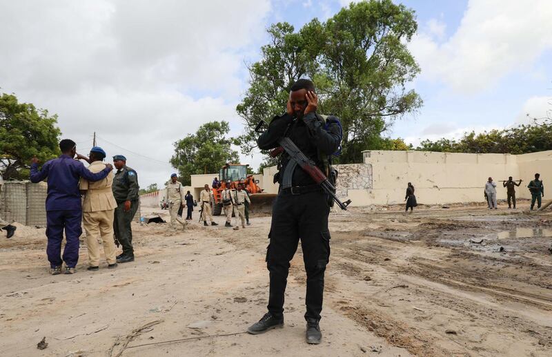 Somali policemen stand at the scene after a suicide car bomber drove into a checkpoint outside the port in Mogadishu. Reuters