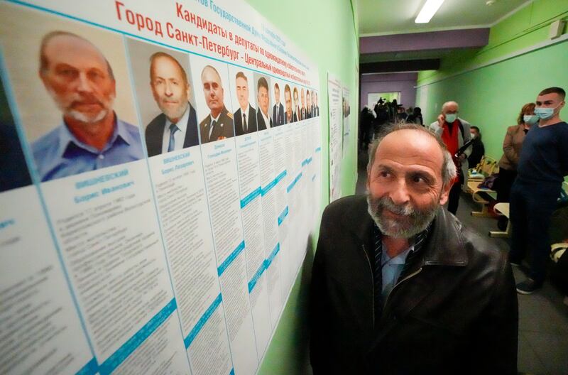 Boris Vishnevsky of the Yabloko party who was running for both the State Duma and the regional legislature, looks at a candidates list in St Petersburg, Russia. Mr Vishnevsky discovered that there were two other men running in both races under the same name as him. AP