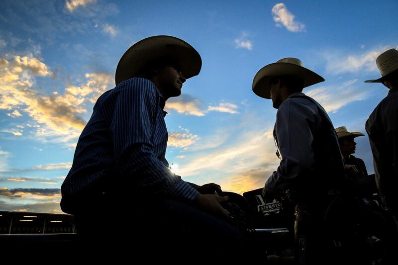 US cowboys hang out behind the chutes during the Xtreme Bulls event of the Garfield County Fair in Rifle, Colorado.  AP