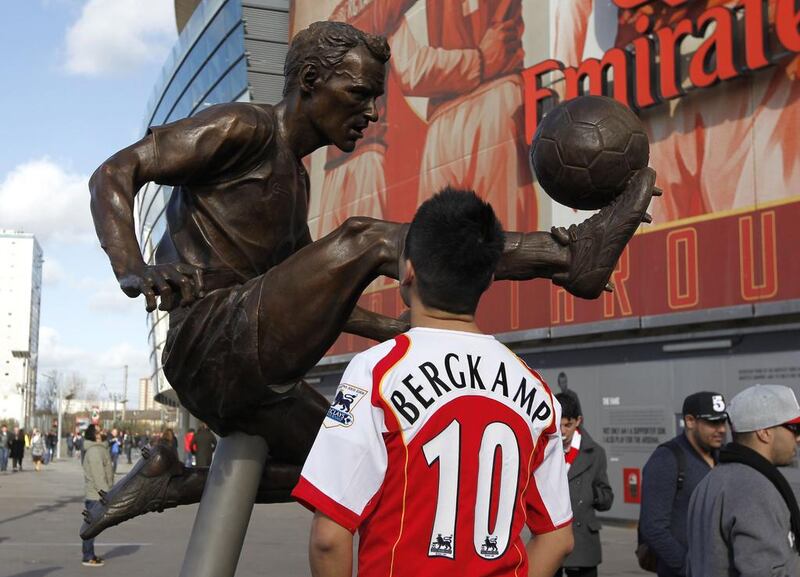 A fan looks at a statue of former Arsenal and Netherlands footballer Dennis Bergkamp after it was unveiled outside The Emirates Stadium in north London on February 22, 2014 ahead of the English Premier League football match between Arsenal and Sunderland. Ian Kington / AFP Photo