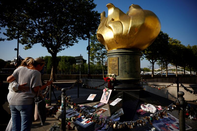 People gather around the Liberty Flame monument above the tunnel of the Alma bridge, where Princess Diana died in a car accident on August 31, 1997, in Paris. Reuters